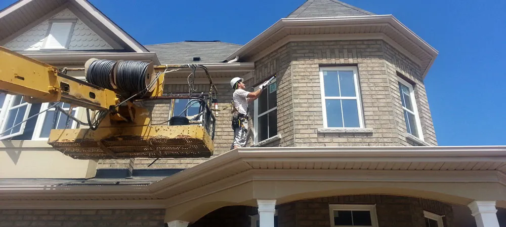 Worker doing caulking in home exterior